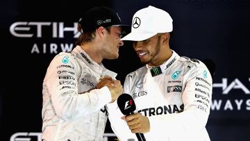 ABU DHABI, UNITED ARAB EMIRATES - NOVEMBER 27: Race winner Lewis Hamilton of Great Britain and Mercedes GP congratulates second place finisher and World Drivers Champion Nico Rosberg of Germany and Mercedes GP on the podium  during the Abu Dhabi Formula One Grand Prix at Yas Marina Circuit on November 27, 2016 in Abu Dhabi, United Arab Emirates.  (Photo by Clive Mason/Getty Images)