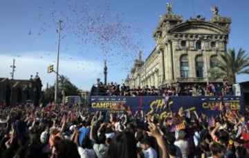 Miles de aficionados acompañan el autocar que traslada a los jugadores y cuerpo técnico del FC Barcelona por las calles de Barcelona.