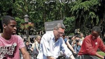 <b>ALCALDE CICLISTA. </b>Alberto Ruiz-Gallardón pedalea en una bicicleta estática entre dos inmigrantes, que representan a las 190 nacionalidades presentes en Madrid.
