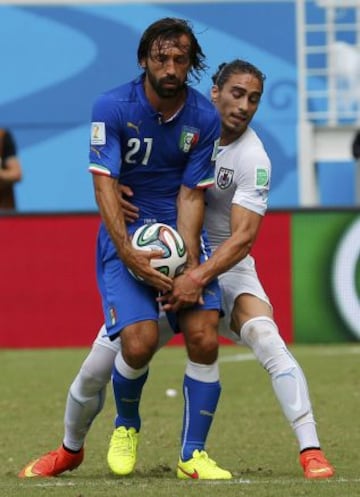 Andrea Pirlo lucha por el balón con el uruguayo Martin Caceres.