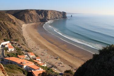 Esta playa nace en una bonita ensenada en forma de concha, resguardada del frío viento y las olas del norte, junto a un núcleo pesquero.  El arenal es extenso —más de 700 metros—, pero estrecho, y se encuentra bordeado de imponentes acantilados negros tallados en pizarra. Mirando hacia el sur, sobresale en el paisaje una roca oscura y estrecha que emerge del mar. Se trata de Pedra da Agulha, todo un icono de la costa vicentina.