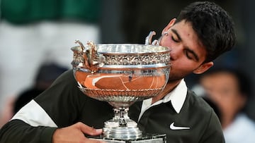 Spain's Carlos Alcaraz kisses the trophy after winning the men's singles final match against Italy's Jannik Sinner on day 15 of the French Open tennis tournament on Court Philippe-Chatrier at the Roland-Garros Complex in Paris on June 8, 2025. (Photo by Dimitar DILKOFF / AFP)