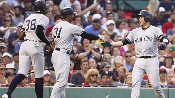 BOSTON, MA - JULY 28: Austin Romine #28 high fives Aaron Hicks #31 of the New York Yankees after Romine hit a two-run home run in the third inning of a game against the Boston Red Sox at Fenway Park on July 28, 2019 in Boston, Massachusetts. Adam Glanzm