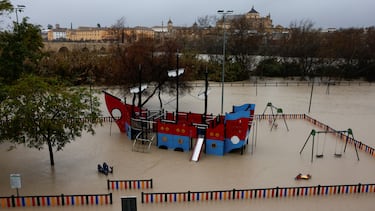 Un parque infantil con forma de barco está rodeado de agua en un parque infantil inundado debido al aumento del caudal del río Guadalquivir, durante las fuertes lluvias en Córdoba.