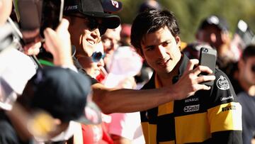 MELBOURNE, AUSTRALIA - MARCH 23: Carlos Sainz of Spain and Renault Sport F1 arrives at the circuit and poses for a photo with a fan before practice for the Australian Formula One Grand Prix at Albert Park on March 23, 2018 in Melbourne, Australia. (Photo by Robert Cianflone/Getty Images)