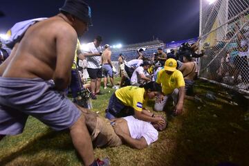 Aficionador auxilian a personas heridas durante una estampida en el Estadio Cuscatlán previo a un partido de la Liga Mayor,  en San Salvador (El Salvador). El partido entre el Alianza y el FAS en el Estadio Cuscatlán tuvo que ser suspendido por una estampida que dejó 12 aficionados muertos, de acuerdo con el informe de la Secretaría de Prensa de la Presidencia.