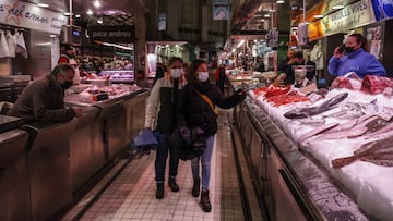 Dos personas pasan por un puesto de pescado en el Mercado Central de Valencia, a 24 de marzo de 2022, en Valencia, Comunidad Valenciana, (Espa&ntilde;a). La Asociaci&oacute;n de Supermercados de la Comunitat (ASUCOVA), la Asociaci&oacute;n Valenciana de C