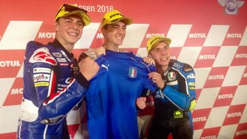 Di Giannantonio, Bagnaia y Migno posando con la camiseta de la selección italiana de fútbol.