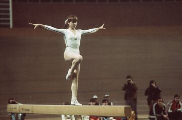 Gimnasta precoz. Con tan sólo catorce años maravillaba y sorprendía a los aficionados de los Juegos Olímpicos de Montreal 1976 con el primer 10. Una cifra nunca vista en una cita olímpica. Giros sobre las barras, con una fuerza y movimientos poco comunes para su corta edad. Esta calificación sorprendió a los espectadores, ya que primero vieron en el marcador el número uno, porque era imposible introducir un número mayor que el 9´95. Rápidamente informaron que era un diez. Añadiría otros dos oros en esos Juegos Olímpicos. En Moscú 1980 sumaría otras dos medallas de oro. A sus apenas dieciocho años dejaba de competir, y el deporte se privó de verla en más Juegos Olímpicos.