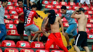 Supporters of Atlas fight with supporters of Queretaro during the Mexican Clausura tournament football match between Queretaro and Atlas at Corregidora stadium in Queretaro, Mexico on March 5, 2022. -