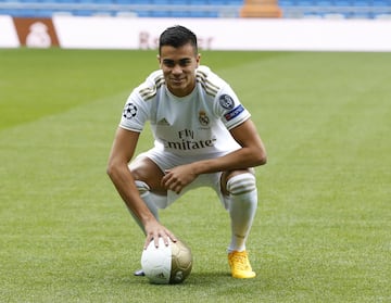 Reinier, vestido de blanco, posa para los medios en el césped del Santiago Bernabéu. 