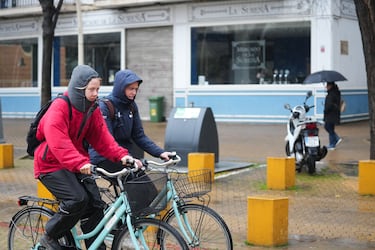 Transeúntes por céntricas calles de Sevilla se protegen de la lluvia que la borrasca 'Leonardo' deja a su paso por Sevilla.