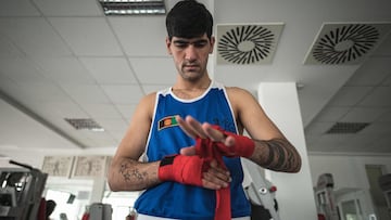 Un boxeador de Afganist&aacute;n se subre las manos antes de ponerse los guantes durante un entrenamiento en Serbia.