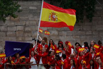 Los abanderados de Espa?a, la regatista T¨¢mara Echegoyen y el pirag¨¹ista Marcus Cooper junto al resto de la delegaci¨®n durante el desfile por el r¨ªo Sena.