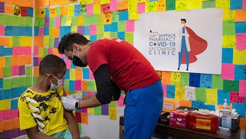 Dr. Mayank Amin puts a band-aid on 10-year-old Ernest "EJ" Jones after administering a booster vaccine at Skippack Pharmacy in Schwenksville, Pennsylvania.