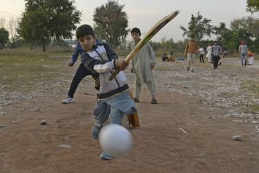 Unos niños paquistaníes juegan un partido de cricket en el patio durante su tiempo de recreo en una escuela de Islamabad. El cricket es el deporte más popular en este país del sur de Asia.