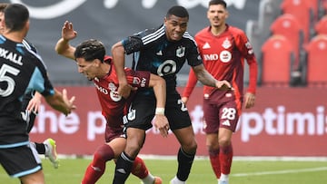 Apr 12, 2025; Toronto, Ontario, CAN; Minnesota United defender Jefferson Diaz (28) takes the ball away from Toronto FC midfielder Theo Corbeanu (7) in the first half at BMO Field. Mandatory Credit: Dan Hamilton-Imagn Images