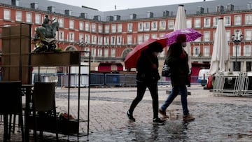 MADRID, 14/11/2020.- Dos personas caminan por la Plaza Mayor este sábado, día en el que se ha comenzado a instalar el tradicional mercadillo navideño. La capital se prepara para unas fiestas navideñas marcadas por el coronavirus con la incertidumbre de las actividades que podrán llevarse a cabo. EFE/Ballesteros
