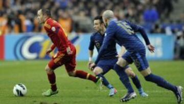 El centrocampista de la selección española, Andrés Iniesta (i) controla el balón perseguido por el centrocampista Mathieu Valbuena.