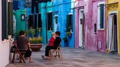 Elderly women sit together in a street of Burano, the most colorful island in the Venice lagoon, on September 11, 2020. (Photo by Tiziana FABI / AFP)