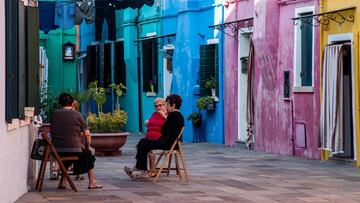 Elderly women sit together in a street of Burano, the most colorful island in the Venice lagoon, on September 11, 2020. (Photo by Tiziana FABI / AFP)