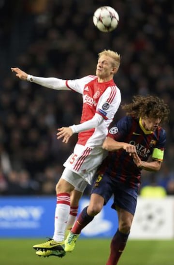 Nicolai Boilesen del Ajax salta por el balon en presencia de Carles Puyol jugador del Barcelona durante el partido que enfrenta a ambos en equipos en Champions league