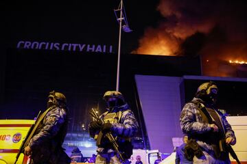 El Crocus City Hall, a las afueras de Moscú, en llamas tras el atentado perpetrado por un grupo de personas vestidas camuflaje y armas de asalto. En la imagen, fuerzas de seguridad rusas desplegadas a las puertas del recinto.