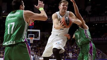 El base esloveno del Real Madrid, Luka Doncic, intenta superar al pivot georgiano del Unicaja, Giorgi Shermadini, en partido de la octava jornada de la Euroliga que se disputa esta noche en el Wizink Center de Madrid.