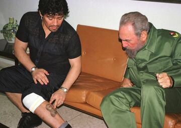 Diego Maradona, en 2001, entonces en Cuba en rehabilitación por abuso de cocaína, muestra al presidente cubano Fidel Castro un tatuaje de él en su pierna. 