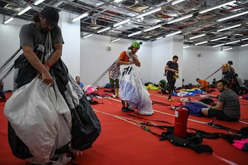 Los saltadores base preparan sus paracaídas antes de saltar desde la plataforma abierta de 300 metros de altura de la histórica Torre Kuala Lumpur de Malasia durante el Salto Internacional de la Torre en Kuala Lumpur