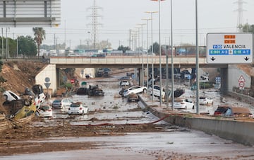 Automóviles dañados a lo largo de una carretera afectada por lluvias torrenciales que provocaron inundaciones, en las afueras de Valencia, España.