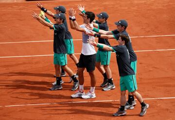 El tenista serbio celebra con unos recogepelotas su victoria en primera ronda ante Marcel Granollers.