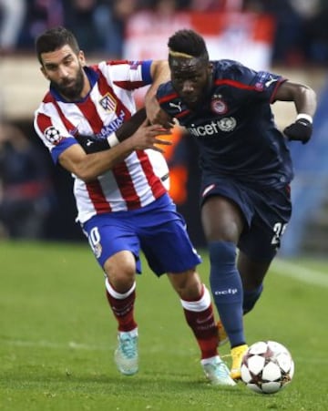El centrocampista turco del Atlético de Madrid Arda Turan lucha el balón con el francés Arthur Masuaku, de Olympiacos, durante el encuentro de la fase de grupos, grupo A, de la Liga de Campeones que se disputa esta noche en el estadio Vicente Calderón, en Madrid.
