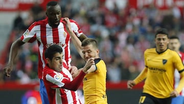 El delantero del Sporting de Gij&oacute;n Carlos Castro, junto a su compa&ntilde;ero, el costarricense Lacina Traor&eacute;, lucha el bal&oacute;n con Ignacio Camacho, del M&aacute;laga CF.