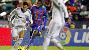 El centrocampista alemán del Real Madrid Mesut Ozil (i) avanza con el balón ante el mediocentro senegalés del Levante Papakouly Diop (detrás), durante el partido de la undécima jornada de Liga disputado esta noche en el estadio Ciutat de Valencia.