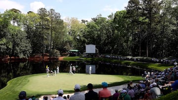 Scottie Scheffler of the United States, Sam Burns of the United States, and Tom Kim of South Korea walk on the green.