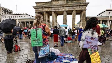 Berlin (Germany), 02/08/2020.- Two demonstrators display placards as they take part in a protest against coronavirus pandemic (COVID-19) regulations in front of the Brandenburg Gate in Berlin, Germany, 02 August 2020. An alliance of right-wing groups have