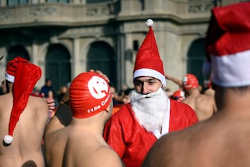 Un participante con gorro de Santa Claus junto a un nadador con gorro de natación.