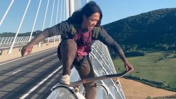 Un skater se prepara para saltar de un puente con su tabla de skate. 