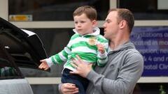 IMAGEN FAMILIAR. Rooney, con su hijo Kai en brazos, se dispone a coger su coche.