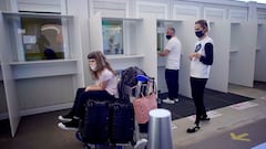 A family waits to do a COVID-19 saliva test after arriving to Argentina from Miami at Ezeiza International airport on the outskirts of Buenos Aires, Monday, Dec. 21, 2020. The last flight from Britain arrived Monday morning after authorities suspended commercial flights to and from Britain amid concerns of new strains of the coronavirus. (AP Photo/Victor R. Caivano)