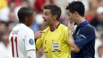 El jugador de la selección inglesa, Ashley Young, discute con el árbitro italiano Nicola Rizzoli (c) mientras el internacional francés Samir Nasri (dcha) observa, durante el partido que juegan las selecciones de Inglaterra y Francia, correspondiente al Grupo D de la Eurocopa 2012, en Donetsk, Ucrania, el lunes 11 de junio 2012.