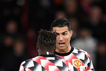 Cristiano Ronaldo (R) speaks to Manchester United's Brazilian midfielder Fred (L) during the warm up prior to the match between Manchester United and Tottenham Hotspur at Old Trafford on October 19, 2022. 