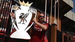 Liverpool fan Paul Davies poses with a cut out of a trophy outside Anfield stadium in Liverpool, north west England on June 26, 2020 after Liverpool FC sealed the Premier League title the previous evening. - Liverpool were crowned Premier League champions