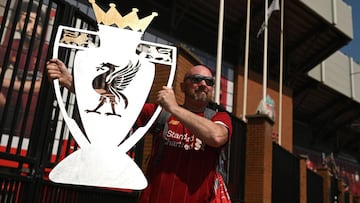 Liverpool fan Paul Davies poses with a cut out of a trophy outside Anfield stadium in Liverpool, north west England on June 26, 2020 after Liverpool FC sealed the Premier League title the previous evening. - Liverpool were crowned Premier League champions