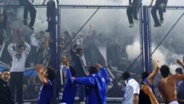 <b>VÉLEZ DEFIENDE LA CORONA. </b>Los jugadores de Vélez celebran la consecución del último torneo de Clausura subidos en el larguero de la portería del estadio José Amalfitani ante la eufórica afición de Liniers.