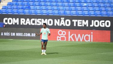 Brazil's forward Vinicius Junior gestures in front of a banner reading "With racism, there is no game" during a training session at the RCDE Stadium in Cornella de Llobregat on June 16, 2023, on the eve of of the friendly football match between Brazil and Guinea. (Photo by Pau BARRENA / AFP)