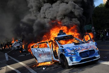 Autos de Waymo arden durante una protesta contra las redadas federales de inmigración en el centro de Los Ángeles.