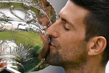 El tenista serbio Novak Djokovic besando el trofeo de campeón del Abierto de Australia.