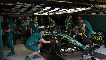 Mecánicos de Aston Martin trabajan sobre el coche de Fernando Alonso durante los test de Bahréin.